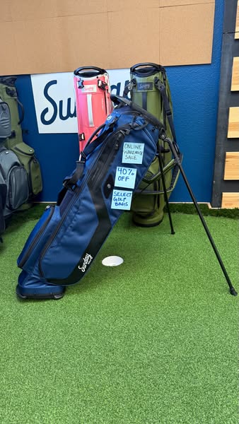 This ad promotes Sunday Golf Bags by highlighting a sale. The image features a blue golf bag with handwritten promotiona