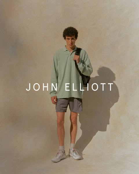This image ad features a single model wearing John Elliott brand athletic and casual wear. The focus is on the brand and