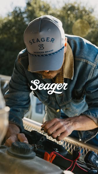 This ad features a man in outdoor work clothes, including a Seager brand hat. The man is working on the engine of a vehi