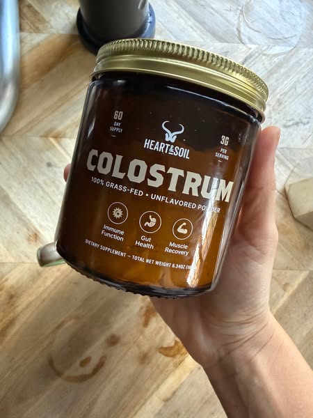 A single-image ad featuring Heart & Soil Colostrum supplement. The ad focuses on the benefits of the supplement, suc