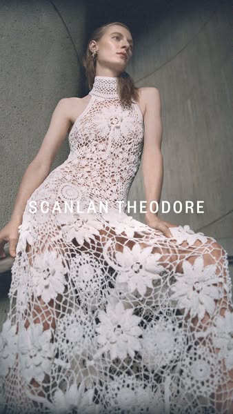 This ad features a woman wearing a lace, floor length Scanlan Theodore dress. 
