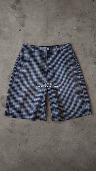 This is an ad for seersucker shorts that features the product laid flat on a concrete surface.