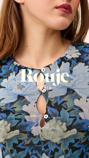 Close up shot of model wearing a floral pattern blouse. The brand name is overlaid in the center of the image.