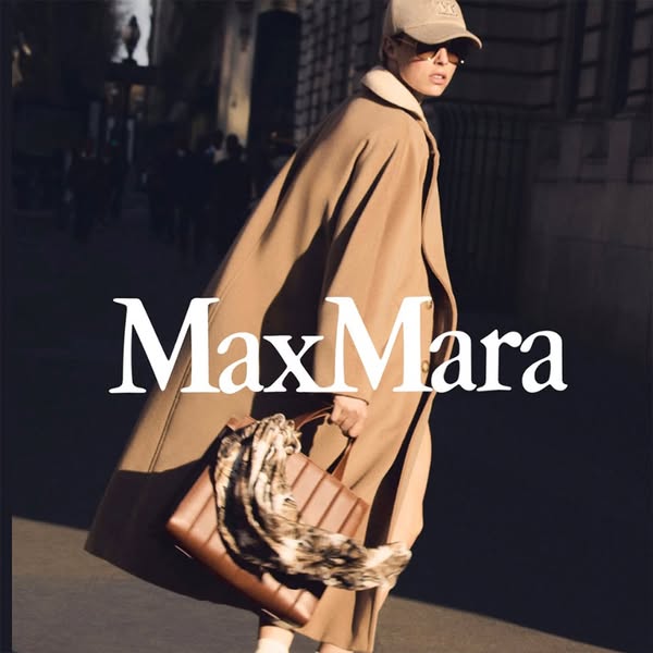 This ad showcases the Max Mara brand with a focus on a woman walking down a city street carrying a handbag and wearing a