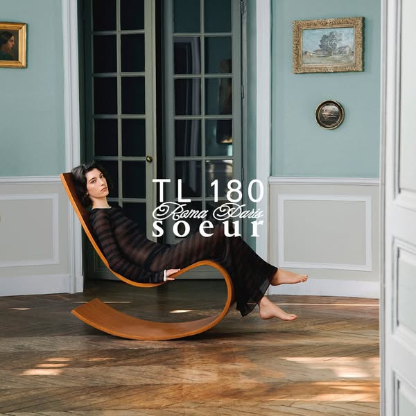 This ad showcases clothing by TL 180 Roma Paris Soeur. A woman reclines in a wooden rocking chair in a well-lit, traditi