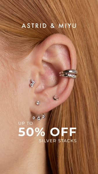 This ad shows an extreme close up of someone's ear, focusing on the earrings and an ear cuff the person is wearing. 