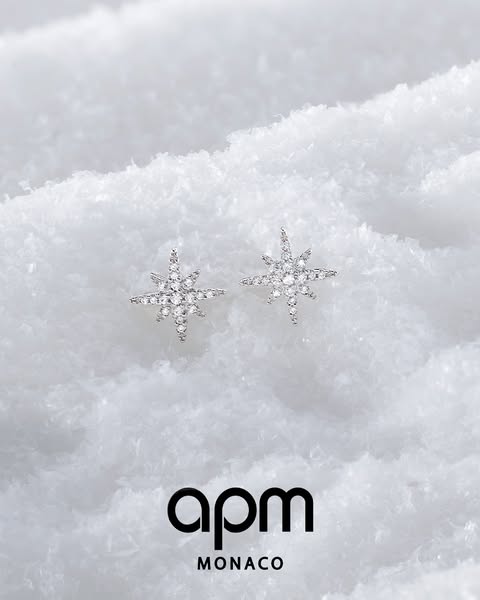 This ad showcases APM Monaco earrings in a wintery setting, emphasizing their sparkle and elegance.