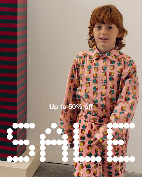 This image ad features a young person wearing a matching pink pajama set with dice printed on it. The ad promotes a sale