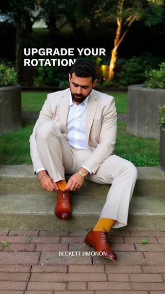 This image ad by Beckett Simonon features a man in a suit sitting on steps and tying the laces of a pair of brown leathe