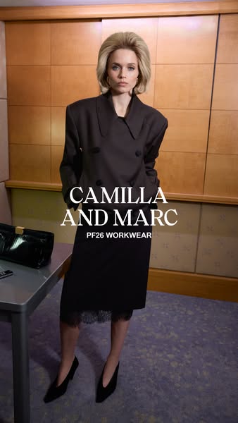 This image ad showcases a woman wearing a dark-colored blazer and dress from Camilla and Marc's PF26 workwear collec