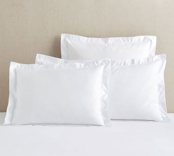 This ad showcases three white pillowcases with a decorative border. The ad focuses on the visual appeal and simplicity o