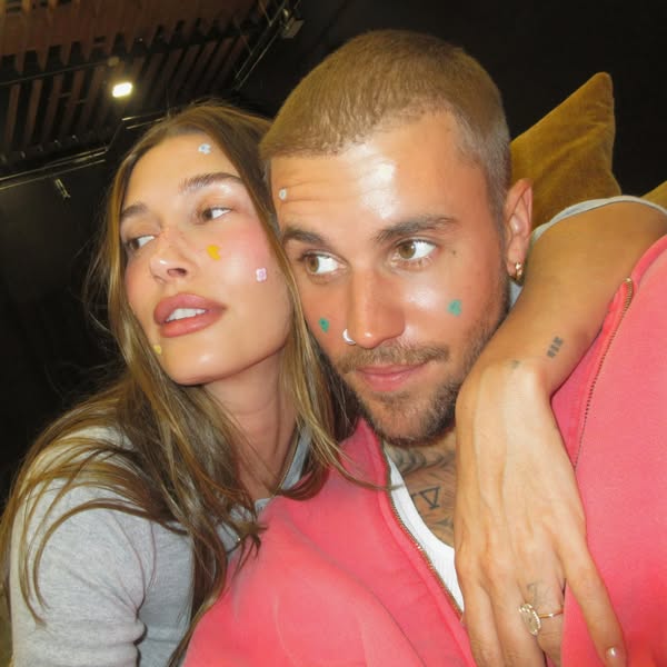 This ad features a close up of Justin and Hailey Bieber, both with stickers on their faces.