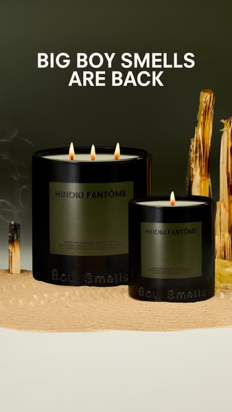 This ad features two Boy Smells Hinoki Fantôme candles, one larger than the other, set on a sandy surface with palo sant