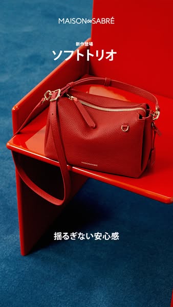 This ad features a red leather bag on a red chair against a blue textured background. The ad highlights the launch of th