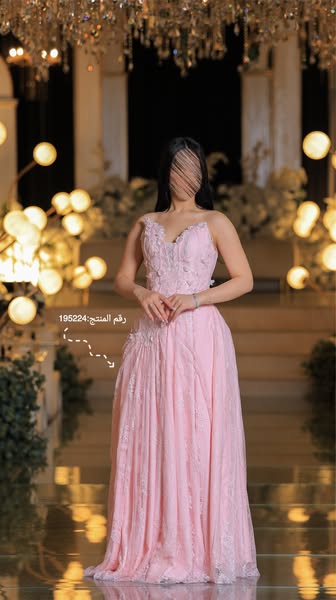 This image ad showcases a floor-length pink gown in a formal setting. The gown features floral detailing and is presente