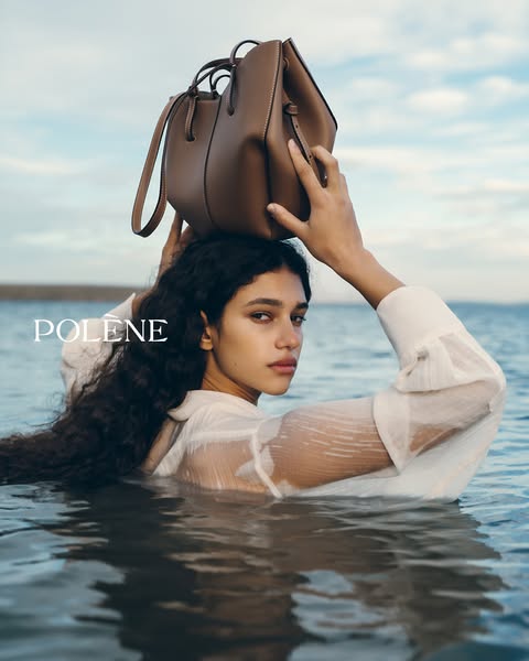 This ad features a woman in the water holding a Polène bag on her head. The ad focuses on the aesthetic of the brand and