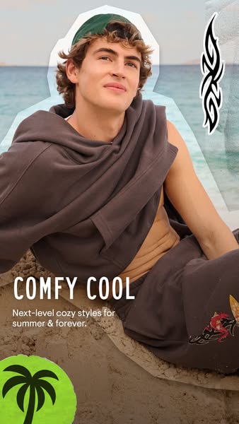 An ad for comfortable clothing. A male model sits on a beach wearing a dark gray sweat suit.