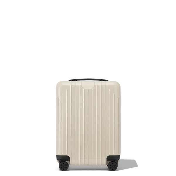 This ad features a single piece of luggage against a white background. The luggage is a light beige color with black whe