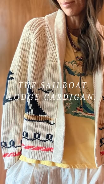 This image showcases a cream knit cardigan with a sailboat design, paired with a sailboat-themed shirt. It promotes the 
