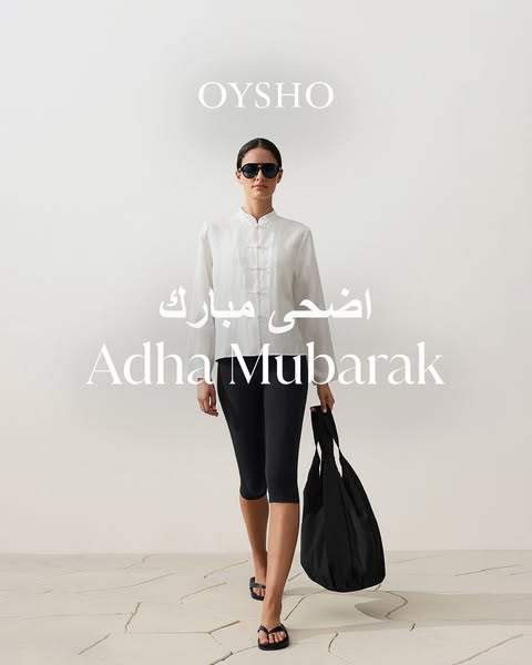 This ad for Oysho features a woman in a casual outfit consisting of a white top and black capri leggings, carrying a bla