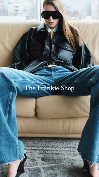 This image ad features a single model reclining on a sofa wearing clothing from The Frankie Shop. The brand's name i
