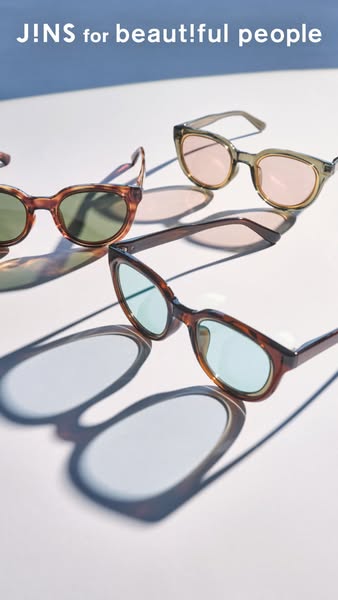 This image ad showcases three pairs of JINS glasses in different styles on a white surface. The headline "J!NS for 