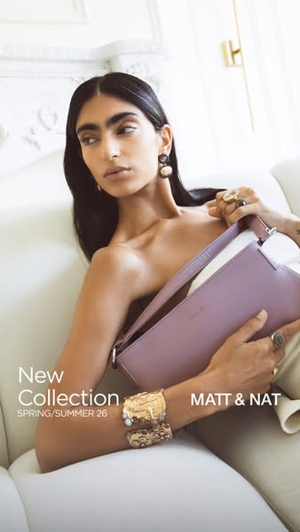 This image ad showcases a woman wearing jewelry and holding a light purple bag by Matt & Nat, highlighting the brand