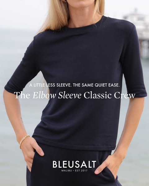 This image ad showcases a navy blue top with elbow-length sleeves from the brand Bleusalt. The focus is on the top's