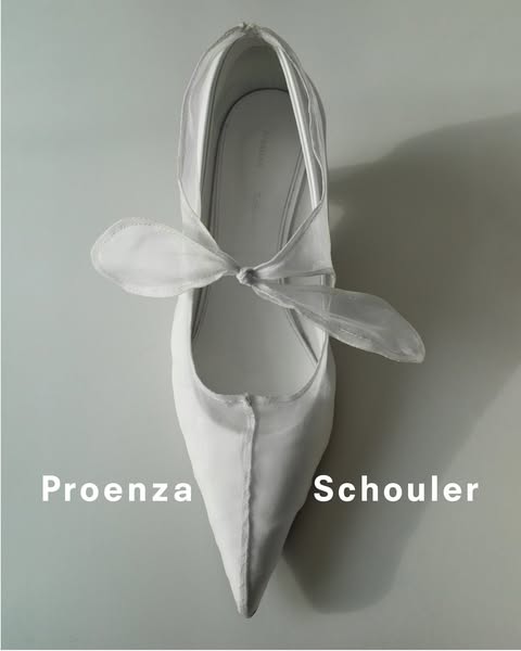 This image showcases a single high-end white shoe from above and the brand name.