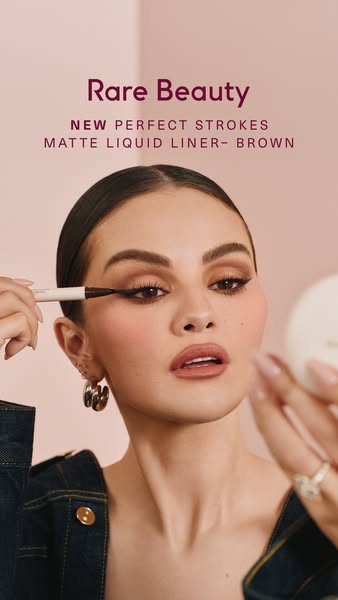 The ad shows a woman applying Rare Beauty's Perfect Strokes Matte Liquid Liner in the shade Brown.