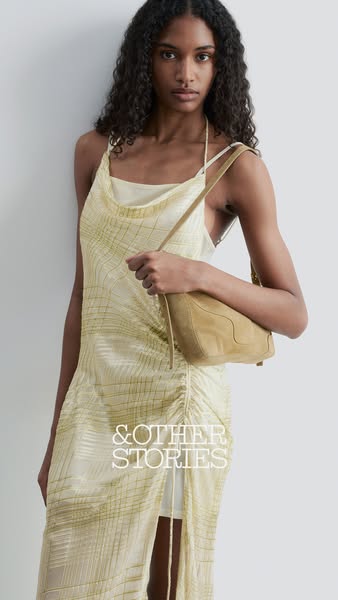 This image ad showcases a woman wearing a flowy dress with a matching purse. The ad focuses on the brand’s aesthetic.