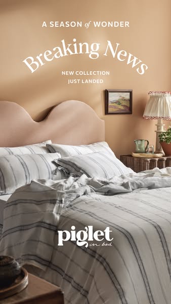 This image ad for Piglet in Bed features a comfortably styled bed with a neutral-toned, striped linen duvet cover and pi