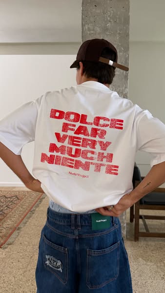 This image showcases a white t-shirt with red lettering on the back, aimed at fashion-conscious consumers who appreciate