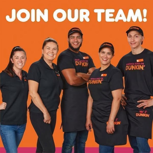 This Dunkin' ad features five smiling Dunkin' employees, three women and two men, standing in front of an orange