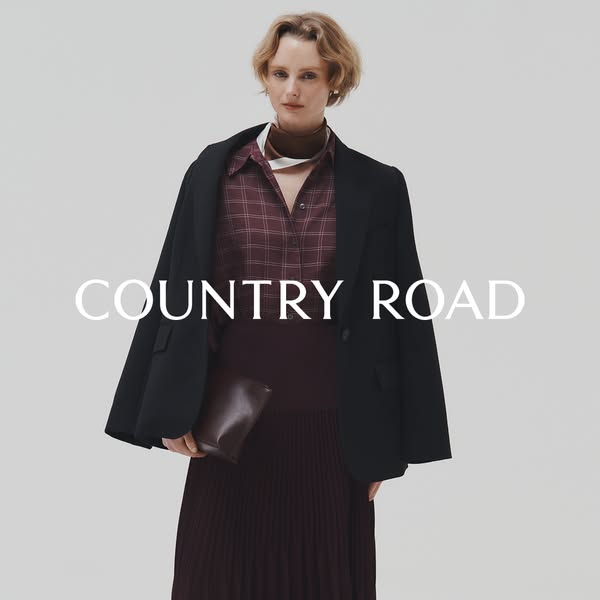 This image ad showcases a woman wearing Country Road brand apparel and carrying a Country Road clutch. The styling is cl