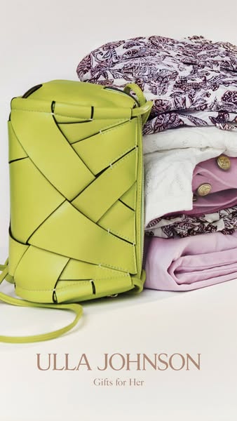 The ad features a lime green woven handbag as a 'gift for her,' presented alongside a stack of folded clothing i