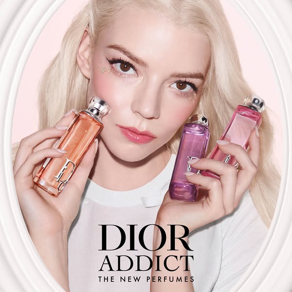 This image ad features Anya Taylor-Joy holding Dior Addict perfumes. The visual aesthetic is clean and polished, highlig