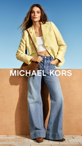 This Michael Kors ad features a model wearing the brand's clothing and accessories. The ad is brightly lit and featu
