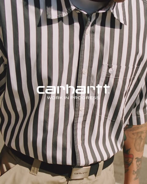 A close-up of a person wearing a Carhartt Work in Progress shirt with the brand logo featured in the center.