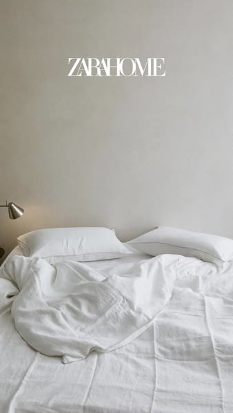 This Zara Home image ad displays a bedroom with a bed covered in white linens. The ad aims to showcase the brand's l