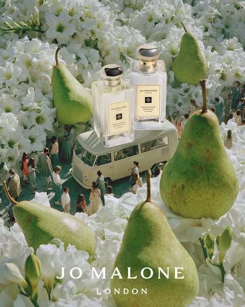 This ad features the Jo Malone English Pear & Freesia cologne. Two bottles of cologne are placed on top of a vintage
