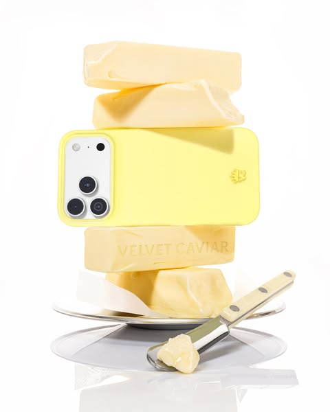 A product shot of a phone case resting atop butter pats, with a butter knife.
