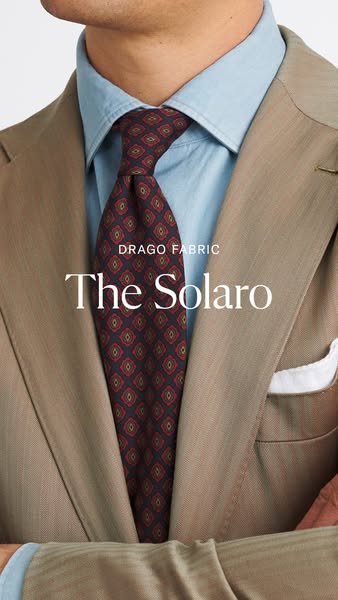 This image ad showcases a tie with a patterned design worn by a model in a light-colored suit and light blue shirt. The 