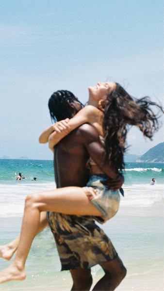 The ad depicts a couple embracing on a beach with an ocean backdrop, conveying a sense of freedom, joy, and romance. The