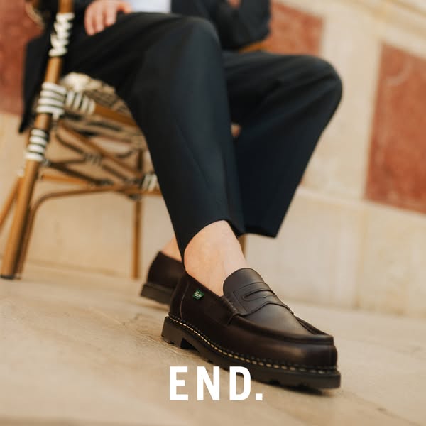 This image ad features a mid-shot of a person sitting in a chair while wearing dress pants and loafers. The ad simply st