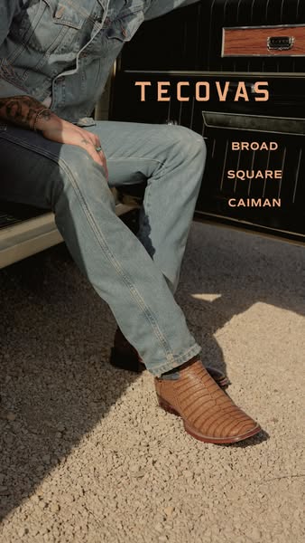 This image ad showcases a pair of Tecovas Broad Square Caiman boots, worn by a person sitting in a vintage car, highligh