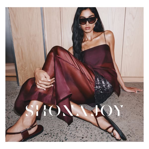 This ad features a woman modeling SHONA JOY clothing and shoes. The brand name is prominently displayed in white text ac