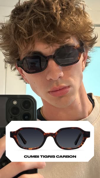 A young man records himself in selfie mode wearing a pair of Cumbi Tigris Carbon sunglasses. He is wearing the product a