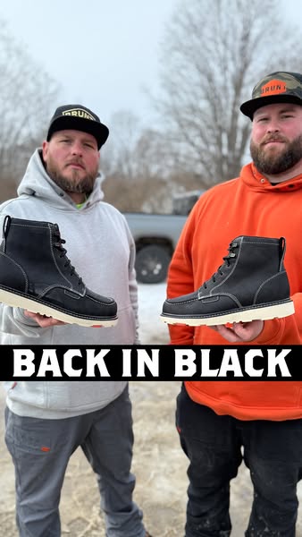 Two people stand outside holding and showcasing the same black work boots. The ad's headline states, "BACK IN B