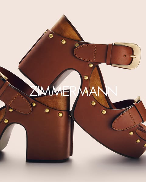 This image ad showcases a pair of Zimmerman platform shoes. The shoes are brown leather with gold hardware, and the Zimm